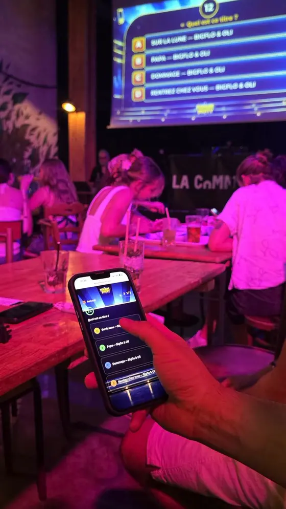 Un téléphone de joueur devant l’écran de la salle